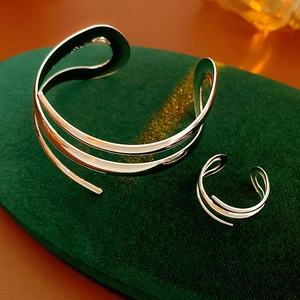Silbernes geometrisches Armreif und Ring Set präsentiert auf elegantem grünen Samt