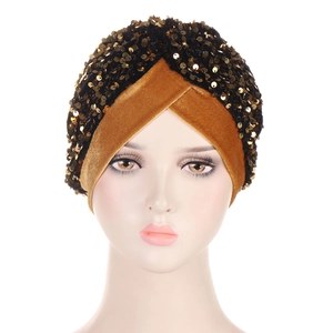 Close-up of golden sequins and black velvet fabric on stylish turban headwrap