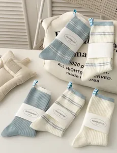Detailed view of cream and light blue striped socks with a blue heart label