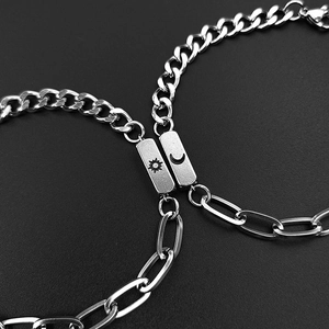 Close-up of magnetic sun and moon charms on stainless steel couple bracelets
