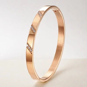Gros plan d'un bracelet en titane or rose orné de trois groupes de zircons incrustés brillants