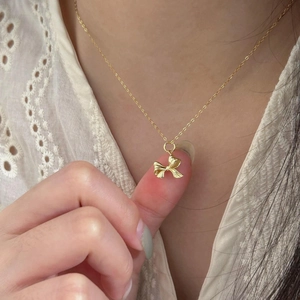 Elegant 925 sterling silver bow-knot pendant necklace worn on white lace background