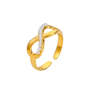 Detail of an open gold-plated ring with infinity symbol inlaid with white pearls