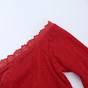 Close-up of red lace fabric detailing exquisite floral patterns and scalloped edges