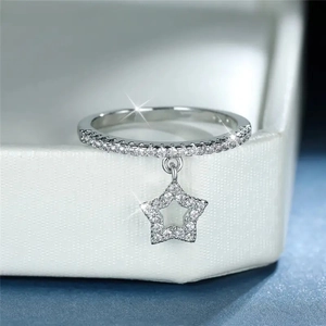 Macro shot of silver ring with dangling hollow star pendant and sparkling zircon pavé