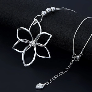Minimalist silver flower pendant necklace with central crystal on a sleek snake chain