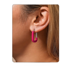 Gros plan d'un modèle portant des boucles d'oreilles en U rose vif et argent doré