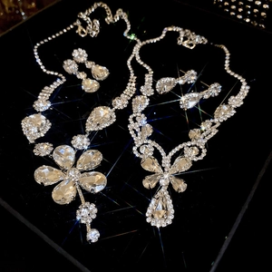 Macro shot of silver-colored crystal flower and teardrop necklace and earring jewelry sets