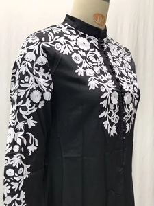 Detail van een etnische jurk met opstaande kraag en witte bloemenborduring