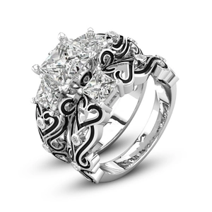 Detail van zilveren ringenset met prinsesgeslepen zirkoon en zwart emaille hartjes