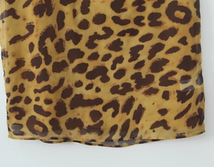 Détail de la texture du tissu en mousseline léopard avec une couture d'ourlet soignée