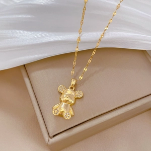 Detail showing a gold titanium bear pendant with micro-inlaid rhinestones on a display box