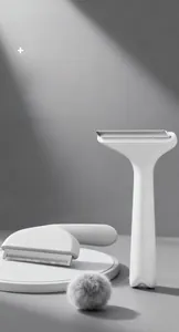 Detail showing white pet grooming brush with curved metal teeth for removing loose fur