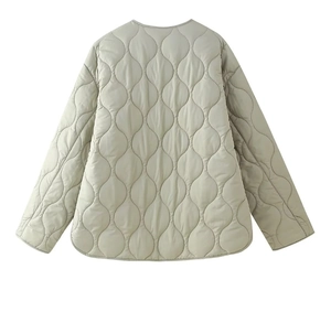 Detail view of wave-quilted light green padded jacket with round neck and premium texture