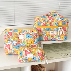 Three-piece quilted cotton toiletry set with colorful graffiti prints and yellow zippers