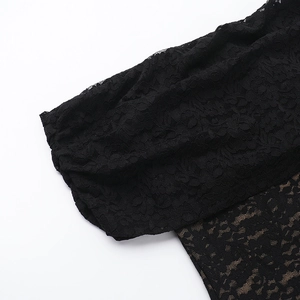 Close-up of intricate black lace fabric showing detailed hollow floral patterns and texture