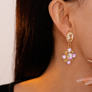Macro view of vintage golden earrings featuring cameo portraits and sparkling crystal charms
