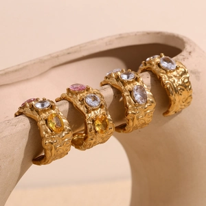 Macro detail of textured 18K gold plated rings with colorful micro-inlaid crystals