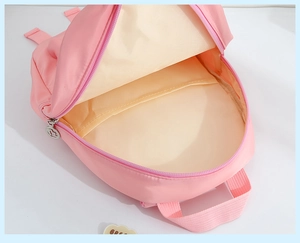 Detail view of pink kids backpack interior showing main compartment and sleeve pocket