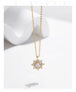 Détail du pendentif flocon en or avec moissanite étincelante sur fond blanc épuré
