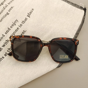 Detail of tortoise shell sunglasses with UV400 lenses and triple rivet accents