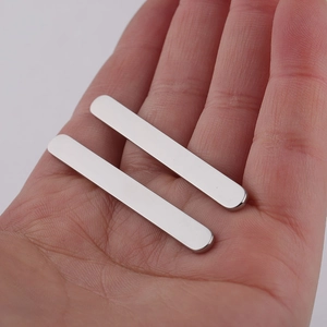 Close-up of two polished 5mm silver stainless steel bars for DIY open rings on a palm