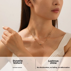 Détail de la parure de bijoux dorés en forme de cœur avec pierres violettes sur mannequin