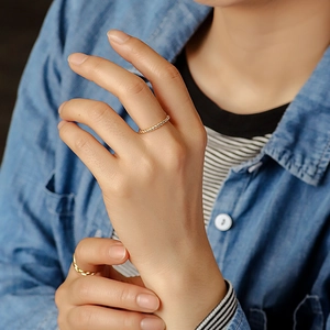 Fashionable gold plated twisted rope ring worn by a model in a minimalist lifestyle setting
