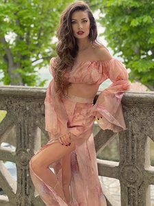 Detail of pink floral off-shoulder crop top and high-slit long skirt in chiffon fabric