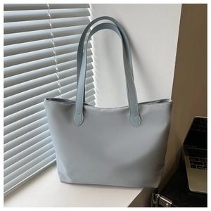 Light blue large capacity tote bag displayed on a windowsill with soft natural sunlight