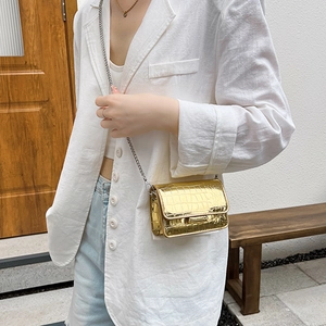 Minimalist gold crocodile embossed chain bag worn with casual summer blazer and jeans