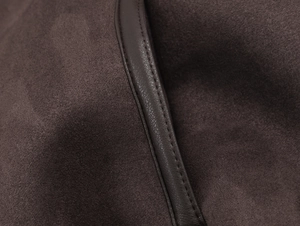 Close-up of chocolate brown jacket detail with suede-like fabric and PU leather piping