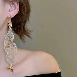Close-up of gold and silver mesh tassel earrings with pearls on model for an elegant look