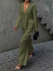 Close-up of green linen two-piece set featuring V-neck long-sleeve top and wide-leg trousers