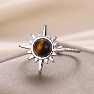 Macro shot of silver sunflower ring with starburst tiger eye stone and spiral band