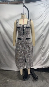 Detail of tweed dress with sequined fabric, velvet trim and silver metallic buttons