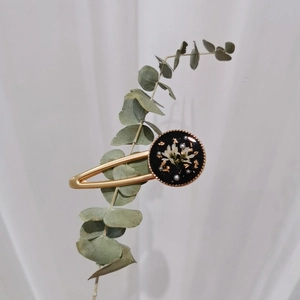 Handmade vintage flower hair clip with gold foil and pearls on a eucalyptus branch