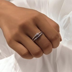 Close-up of stacked S925 sterling silver rings with purple and white zircon gemstones