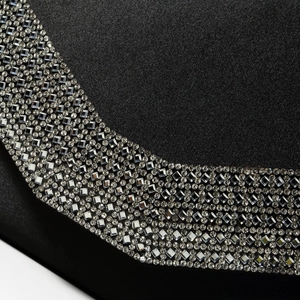 Macro shot of shimmering rhinestones on black fabric evening bag for festive luxury