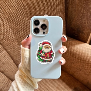 Close-up of a light blue phone case with Santa Claus sticker held in hand