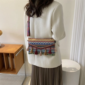 Detail of bohemian crossbody bag with colorful woven patterns and decorative tassels