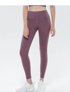 Detail of high-waisted seamless yoga leggings in dark purple with peach lift effect