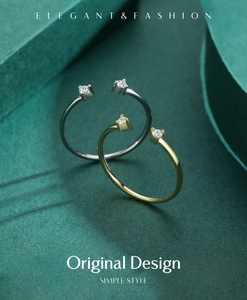 Detailed view of minimalist gold and silver adjustable rings with crystals on green backdrop