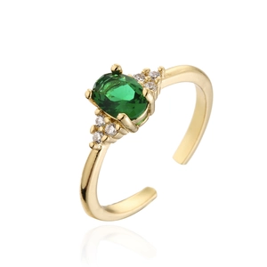 Macro shot of 18K gold ring featuring an oval green gem and micro-set zircon side stones