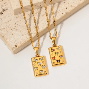 Macro detail of 18K gold-plated rectangle butterfly pendant with white zircon stones