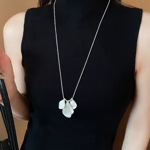 Elegant long necklace featuring layered white petal pendants on a slim silver chain