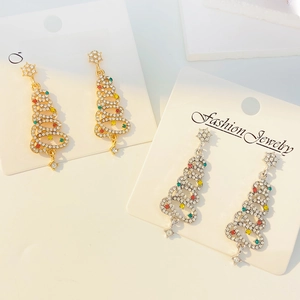 Dettaglio degli orecchini ad albero di Natale con strass e gemme colorate su carta