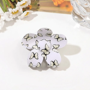Detailed top view of a white flower hair claw clip with yellow butterfly prints