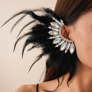 Detailed close-up of Bohemian feather earring with crystals on model's ear