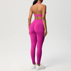 Dettaglio del completo yoga rosa rosso con top scoperto e leggings a vita alta